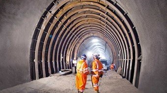 Two construction workers with orange costumes in a tunnel