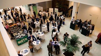 People next to bar tables networking in an event - view from above