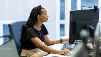 kvinde med langt brunt hår siddende på en computer